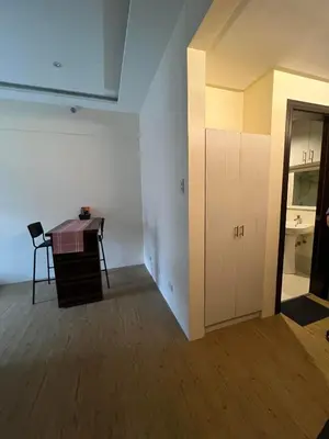 an empty room with a desk and a table at Chelsea Tower 3 in Manila