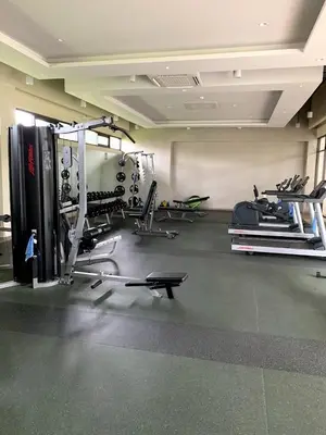 a gym with several treadmills and machines in a room at Chelsea Tower 3 in Manila