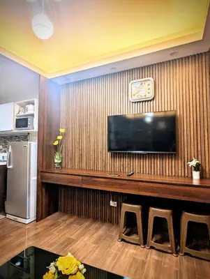 a living room with a flat screen tv on a wall at 1 bedroom Cozy Escape in Manila