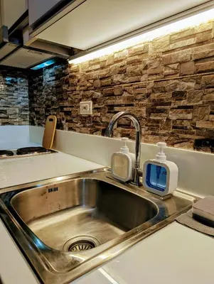 a kitchen sink with two soap dispensers on it at 1 bedroom Cozy Escape in Manila