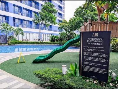 a slide in front of a swimming pool with a building at 1 bedroom Cozy Escape in Manila