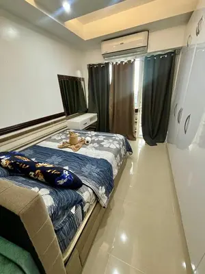 a bedroom with two beds and a tv on the wall at White House Staycation by Trixie Datiles in Manila