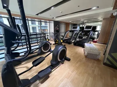 a gym with several treadmills and exercise bikes at Gentry Manor Family Room 2 Beds Near Okada MOA NAIA 8E in Manila