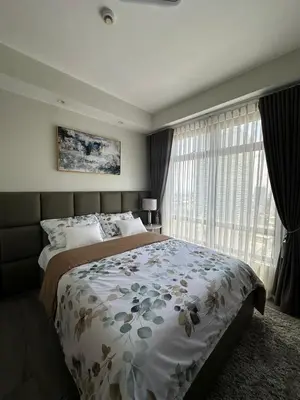 a bedroom with a bed and a large window at La nobleza terrazas condominium in Manila