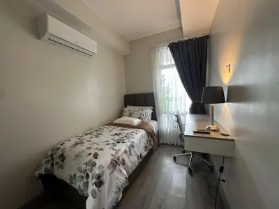a bedroom with a bed and a desk and a window at La nobleza terrazas condominium in Manila