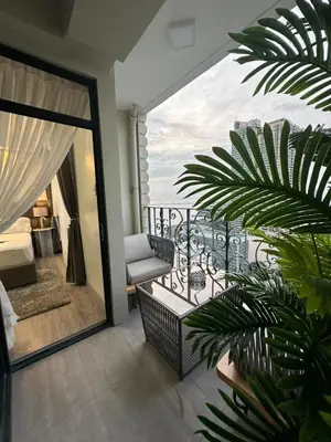a room with a balcony with a view of the ocean at La nobleza terrazas condominium in Manila