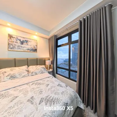 a bedroom with a bed and a large window at La nobleza terrazas condominium in Manila