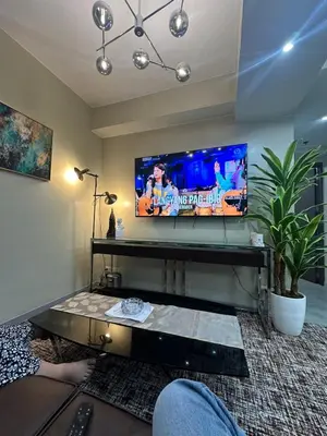 a person sitting in a living room watching a tv at La nobleza terrazas condominium in Manila