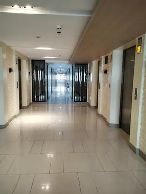 an empty hallway in a building with glass doors at Shore2 tower2 11th floor, unit 1122 VSV Luxury Family Suite staycation Moa in Manila