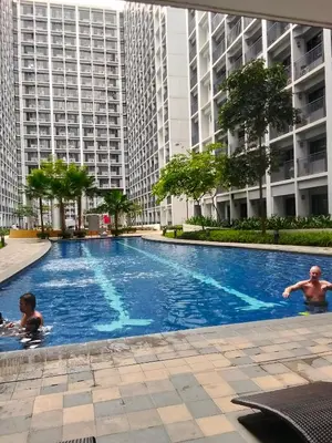 people swimming in a swimming pool in a building at Shore2 tower2 11th floor, unit 1122 VSV Luxury Family Suite staycation Moa in Manila