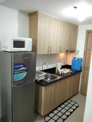 a kitchen with a microwave on top of a refrigerator at Shore2 tower2 11th floor, unit 1122 VSV Luxury Family Suite staycation Moa in Manila