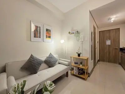 a living room with a couch and a table at 1BR Condotel with Balcony at FAME Residences #FM64 in Manila
