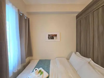 a bedroom with a bed with a book on it at 1BR Condotel with Balcony at FAME Residences #FM64 in Manila