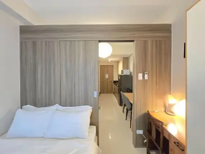 a hotel room with a bed and a desk and a kitchen at 1BR Condotel with Balcony at FAME Residences #FM64 in Manila