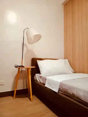a bedroom with a bed and a lamp on a table at Kaunis Hive Hope Residences in Trece Martires