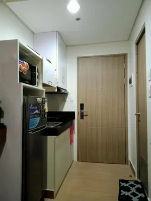 a kitchen with a refrigerator and a door to a room at Kaunis Hive Hope Residences in Trece Martires