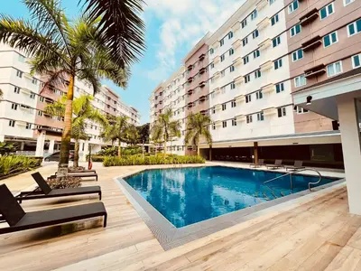 a swimming pool in front of a building at Kaunis Hive Hope Residences in Trece Martires