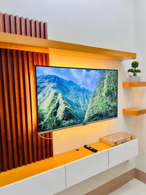 a flat screen tv sitting on top of a wall at Claire's place in Manila