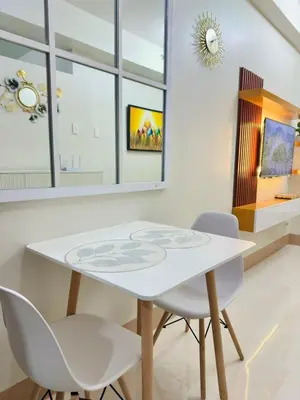 a white dining room with a white table and two chairs at Claire's place in Manila