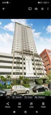 a large white building with cars parked in front of it at Laureano di trevi tower 2 Condominium Corporation in Manila