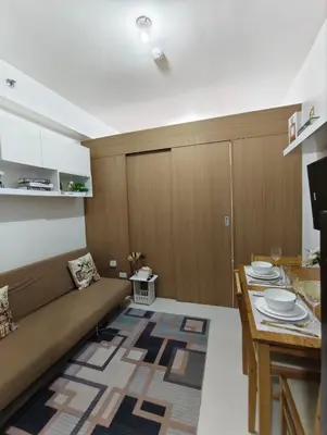 a living room with a couch and a table at Stylish Condo with City View and Netflix - Pool Access in Manila