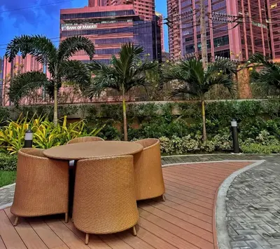 a patio with a table and chairs in a city at Stylish Condo with City View and Netflix - Pool Access in Manila