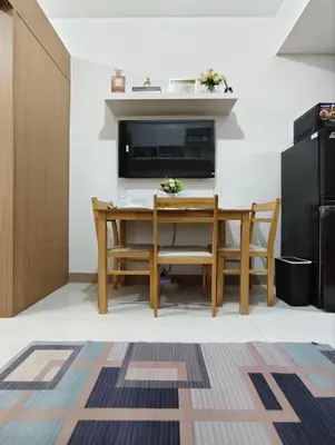 a dining room with a table and a tv at Stylish Condo with City View and Netflix - Pool Access in Manila