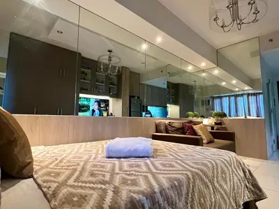 a bedroom with a bed and a living room at Modern Comfort Living! Netflix Ready in Manila