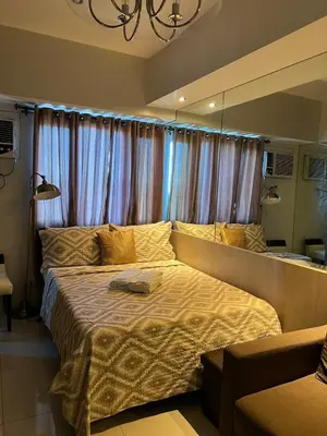 a bedroom with a large bed in front of a window at Modern Comfort Living! Netflix Ready in Manila