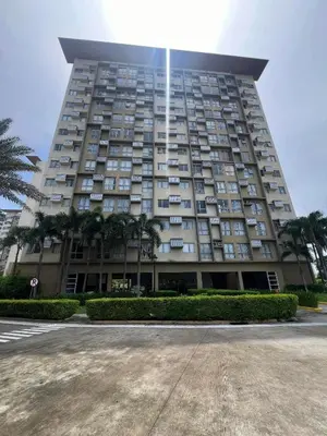 a tall building with palm trees in front of it at Chelsea Tower 1 in Manila