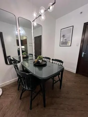 a dining room with a black table and mirrors at Chelsea Tower 1 in Manila