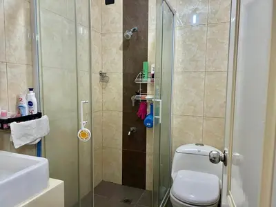 a bathroom with a shower with a toilet and a sink at A cozy condo within the center of Manila in Manila