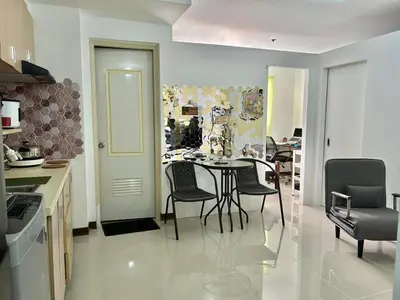 a kitchen with a table and chairs in a room at A cozy condo within the center of Manila in Manila