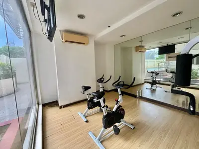 a gym with treadmills and exercise bikes in a room at A cozy condo within the center of Manila in Manila