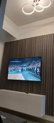 a flat screen tv on a wall with a tennis game at S-Residence Staycation Near IKEA,MOA,PICC in Manila