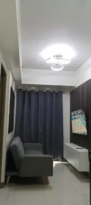 a living room with a couch and a black curtain at S-Residence Staycation Near IKEA,MOA,PICC in Manila