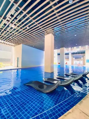 a swimming pool with blue tiles in a building at S-Residence Staycation Near IKEA,MOA,PICC in Manila