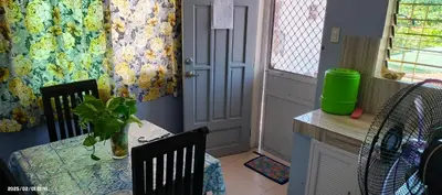 a dining room with a table and chairs and a door at Fazing in Bacoor
