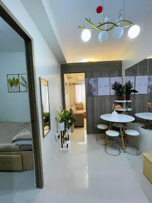 a room with a table and chairs and a bed at Field Residences Condominium in Manila