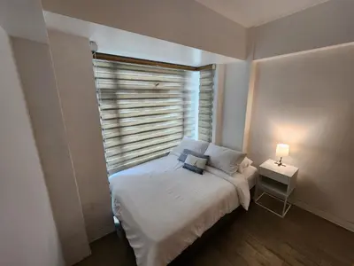 a small bedroom with a bed and a window at 1BR Condo w Balcony near NAIA, Casino, Newport in Manila
