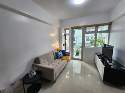 a living room with a couch and a television at 1BR Condo w Balcony near NAIA, Casino, Newport in Manila