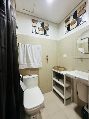 a bathroom with a toilet and a sink at RED RESIDENCES Makati in Manila
