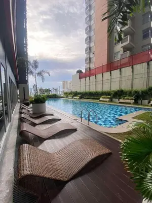 a row of cushioned chairs sitting next to a swimming pool at RED RESIDENCES Makati in Manila