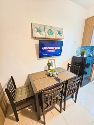 a dining room with a table and chairs and a tv at Tokyo Oasis at Shore 1 Residences Tower A, Pasay, MOA in Manila