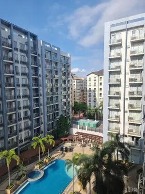 an apartment complex with a swimming pool and palm trees at One Palm Tree Villas in Manila