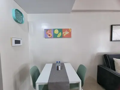 a dining room with a white table and green chairs at One Palm Tree Villas in Manila