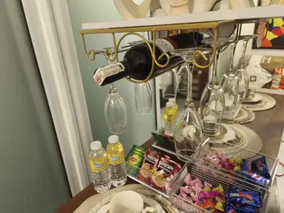 a table with wine glasses and bottles on a shelf at Paris Hilton Beach resort in Manila