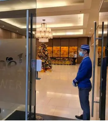 a man wearing a mask standing in a lobby at Executive Suite 519A at Shell Residence by GK Condotel in Manila