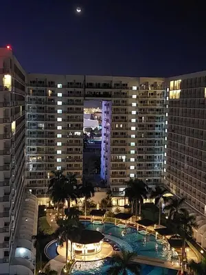 a large building with a swimming pool at night at Executive Suite 519A at Shell Residence by GK Condotel in Manila