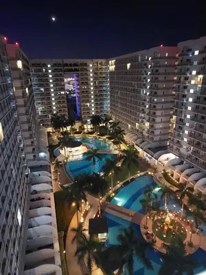 an overhead view of a hotel with pools at night at Suite 1443D at Shell Residence by GK Condotel in Manila